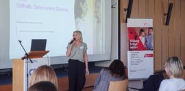 Eine Dame redet vor Publikum 