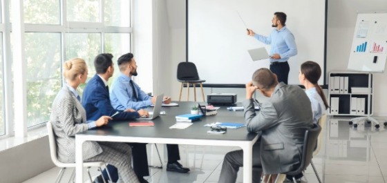 Trainer mit kleiner Gruppe am Flipchart 