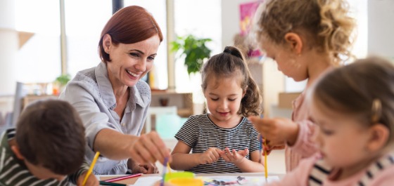 Eine Frau betreut Kinder in einer Kita 