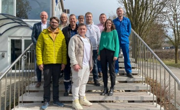 Eine gemischte Gruppe von Personen steht auf einer Treppe 