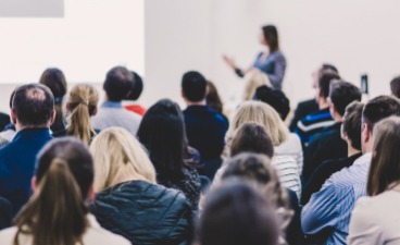 Eine Frau hält einen Vortrag vor Zuschauern