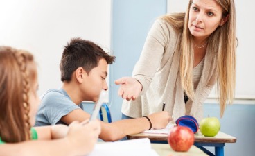 Eine Lehrerin mit Kindern die Handy benutzen