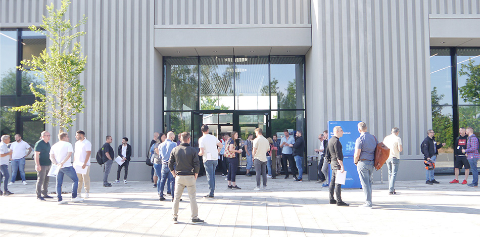 Die Teilnehmenden des Industriemeistertages Mittelfranken stehen vor dem Veranstaltungsgebäude und unterhalten sich.