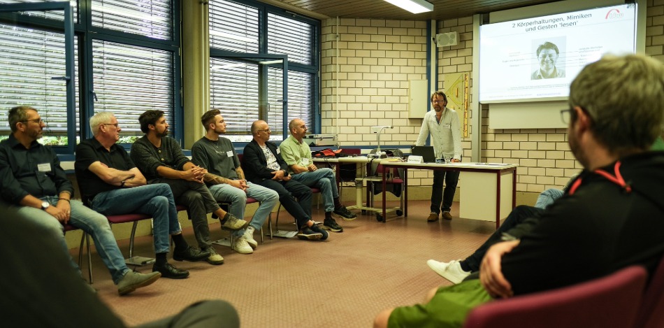 Rund 20 Menschen sitzen in einem Workshop im Kreis 