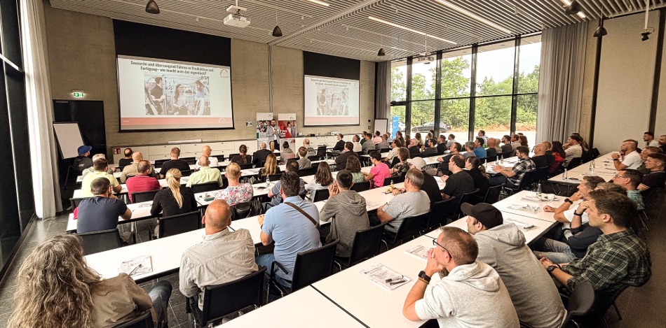 Ein großer Saal mit vielen Personen, die einem Vortrag zuhören