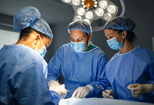 Mehrere Ärzte und Schwestern mit Mundschutz in einem Operationssaal