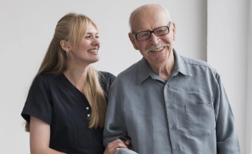 Gerontopsychiatrische Fachkraft Eine weibliche Pflegerin neben einem alten Mann