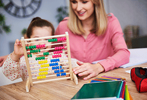 Frau spielt mit Kind ein Spiel im Kindergarten 