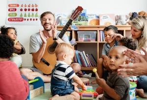 Mann mit Gitarre im Kindergarten und Kinder 